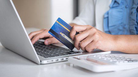 Women shop online with laptops and credit cards.