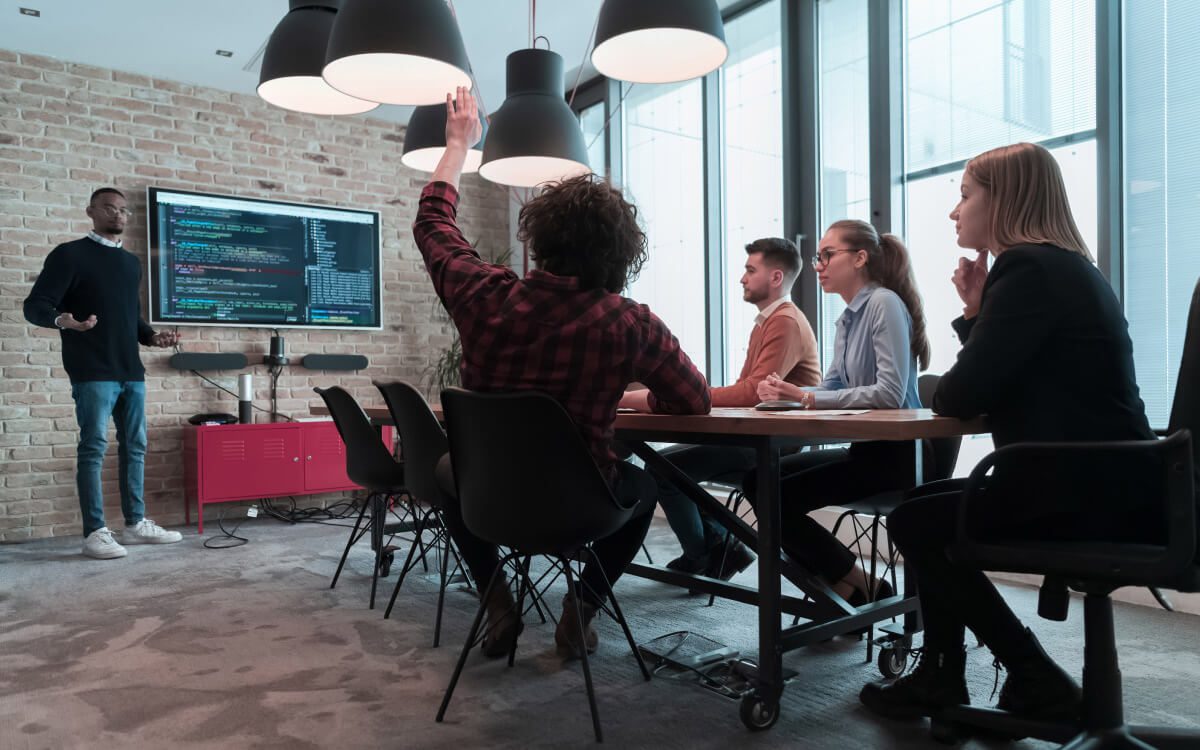 Five Individuals Engaged in a Professional Meeting Within a Modern Office Setting.