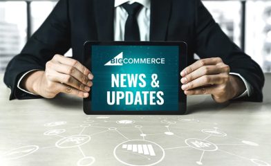 A Man Holding a Tablet Displaying 'Bigcommerce News & Updates' With Icons Drawn on the Table.