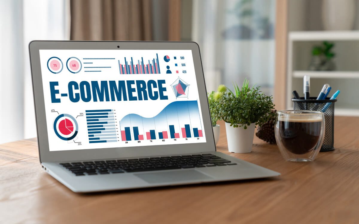 An Open Laptop on a Wooden Desk Displaying Colorful Graphs and Charts With the Title 'E-Commerce' in Bold Letters.