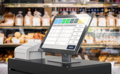 A Modern Point of Sale (POS) System With a Touchscreen Display Showing Various Buttons Such as 'Bread', 'Cheese,' 'Snacks,' and Other Categories in a Bakery Setting.