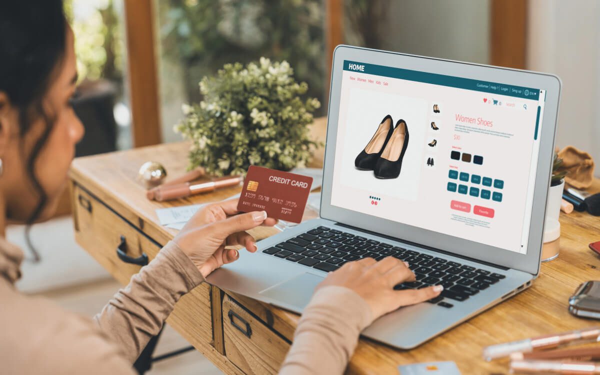 A Person Browsing An eCommerce While Holding a Credit Card in One Hand.
