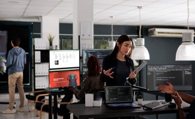 An Office Setting With Multiple Individuals Engaged in Various Tasks.