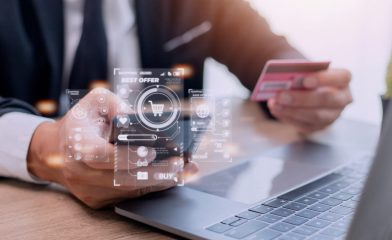 A Person Making an Online Purchase Using a Futuristic Holographic Interface While Holding a Pink Credit Card.