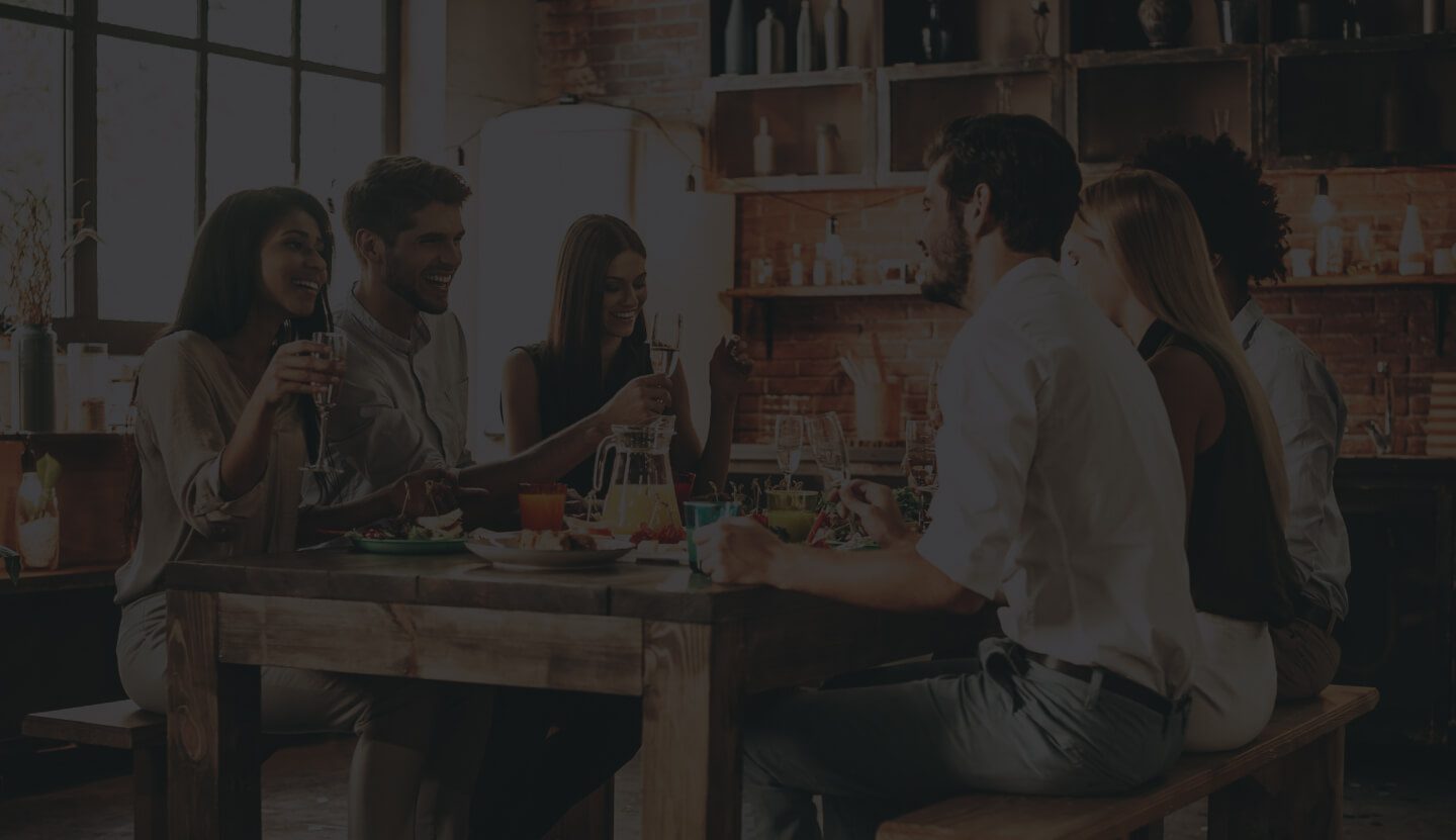 A Group of People Enjoying a Meal Together in a Cozy, Well-Lit Environment.