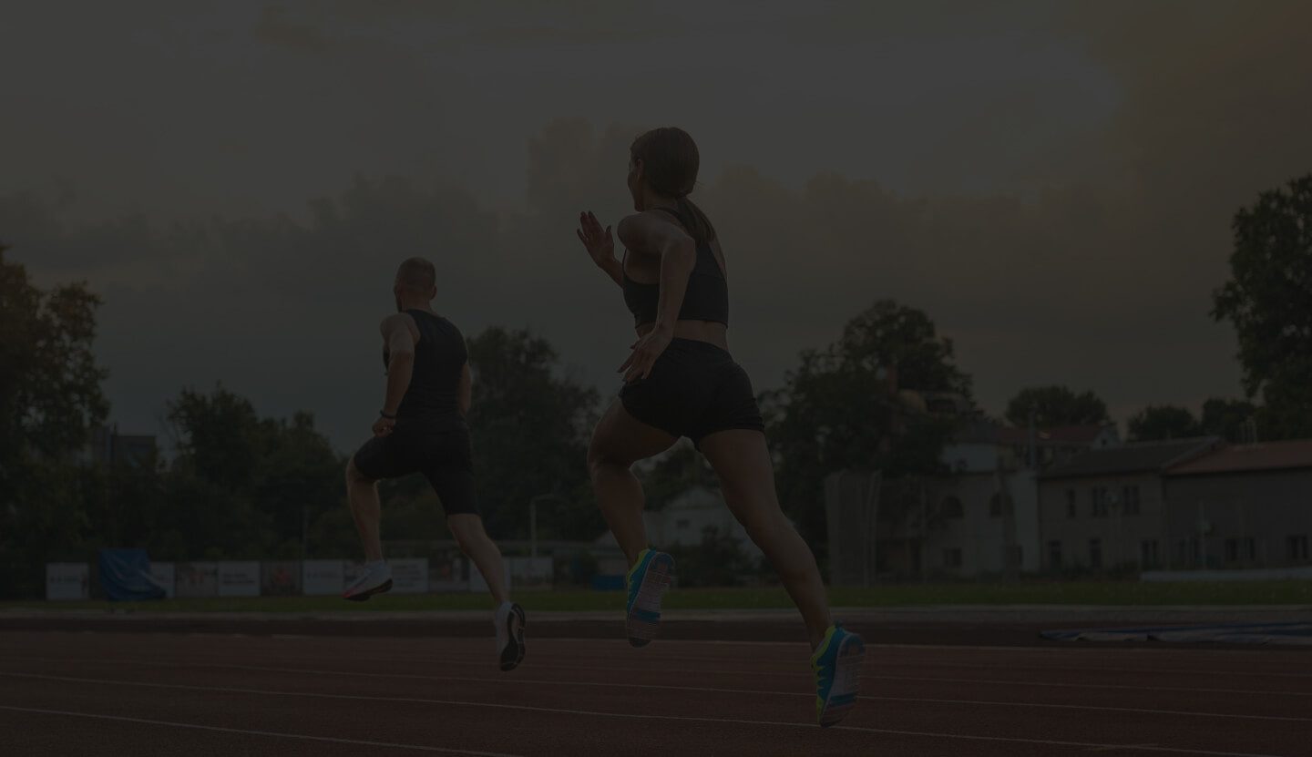 Two Individuals Engaged in a Running Activity on a Track.