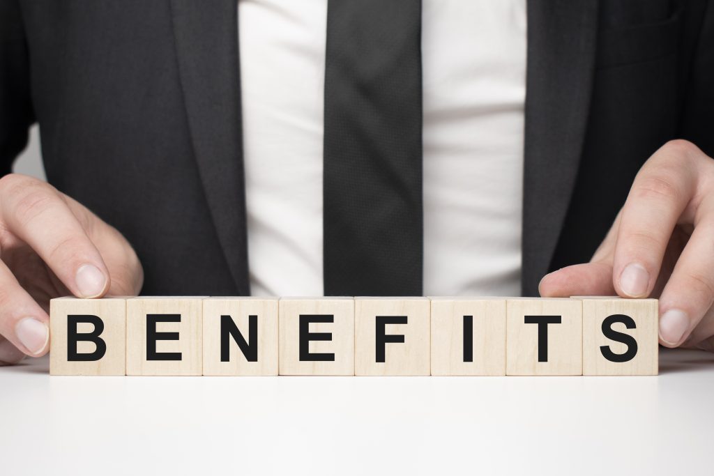 Businessman arranging blocks to spell the word "BENEFITS."