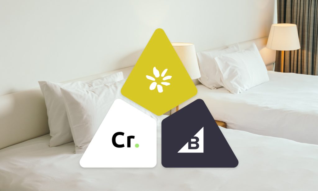 Bed with two pillows featuring a triangle logo.