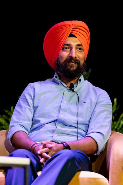 Amandeep Singh, founder of Cronix LLC, sits calmly on a stage and addresses the audience at the BigCommerce BigSummit 2024 event.