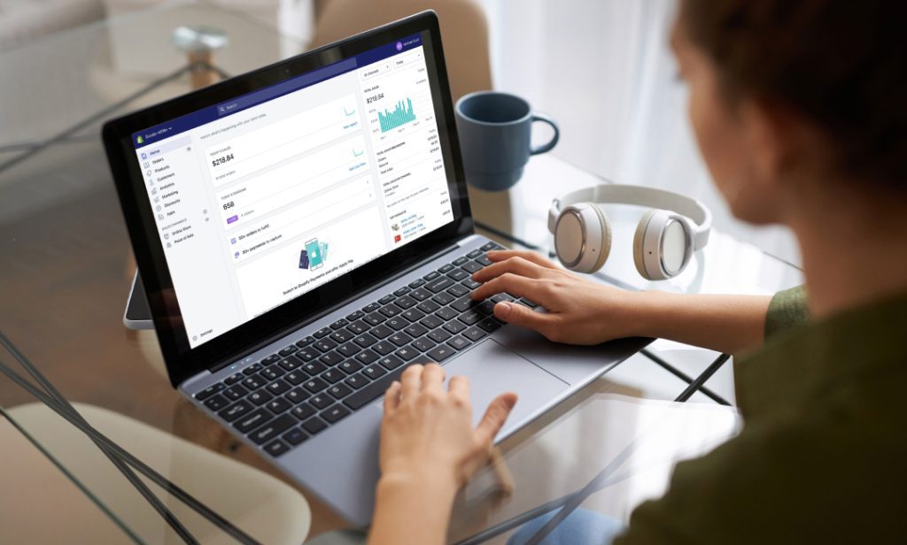 A woman working on a laptop with Shopify's dashboard on the screen.