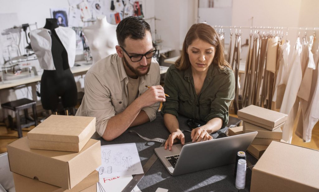 Fashion entrepreneurs preparing orders in a bustling design workshop.
