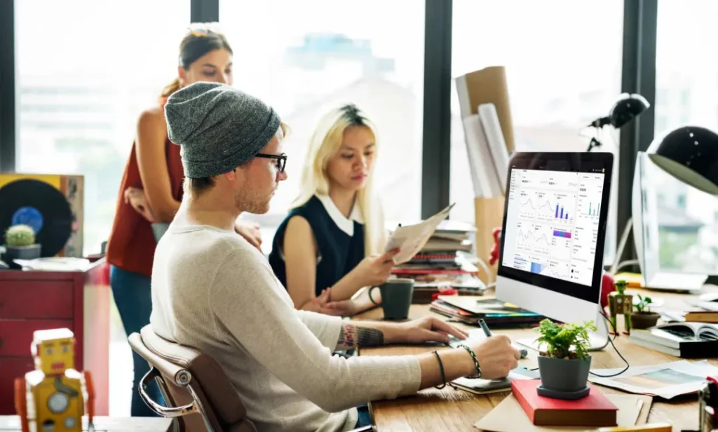 Three Shopify Plus developers analyzing data on a computer