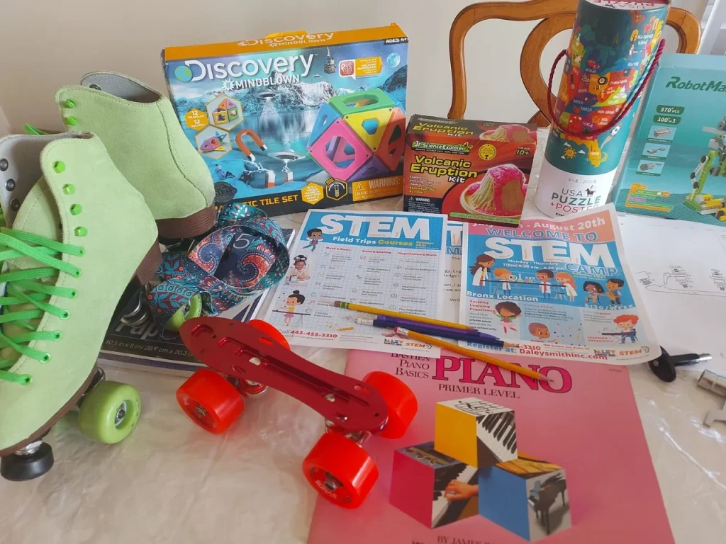 STEM materials from Daley Smith STEM: roller skates, science kits, puzzles, piano book, and flyers promoting hands-on learning and creative exploration.
